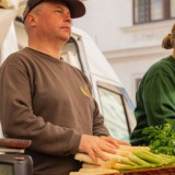 Bild anzeigen: Blatt und Knolle, Marktstand mit Verkäufer